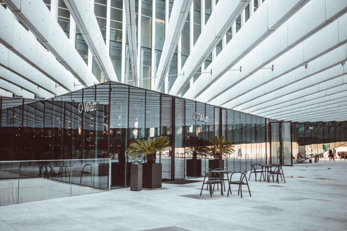 A restaurant inside a mall with tables with chairs outside