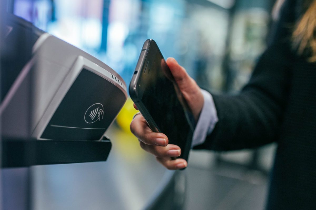 A person holding a mobile phone on a scanning device